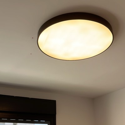 מנורת תקרה עגולה דולקת על תקרה לבנה