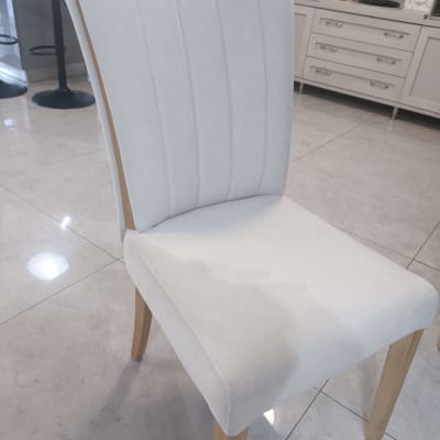 כיסא מרופד בבד בהיר עם רגלי עץ