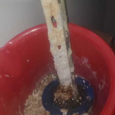 גוף חימום עם אבנית בתוך דלי אדום