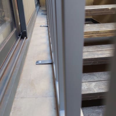 מעקה מתכת ליד חלון זכוכית ומדרגות עץ