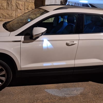 רכב לבן חונה ליד קיר אבן