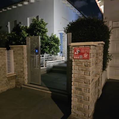 שלט אזהרה על מצלמות אבטחה ליד שער כניסה