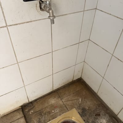 ברז מים על קיר אריחים עם ניקוז ברצפה