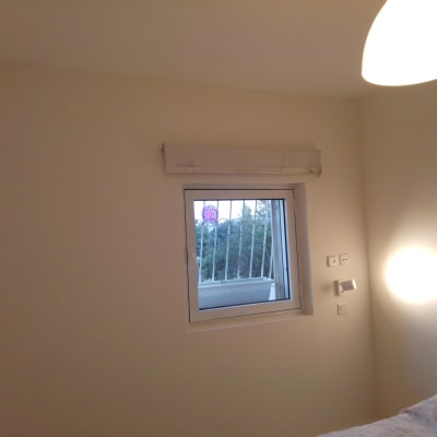 קיר צבוע בצבע בהיר עם חלון קטן