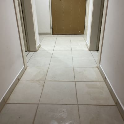 רצפת אריחים נקייה במסדרון עם דלת עץ