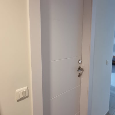 דלת לבנה עם ידית מתכת בקיר פנימי