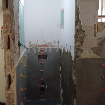 חדר בשיפוץ עם קירות חשופים ואריחים מותקנים