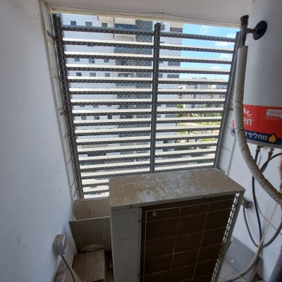 רשת מתכת מותקנת על חלון למניעת כניסת יונים