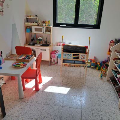 חדר ילדים מסודר עם צעצועים ורהיטים