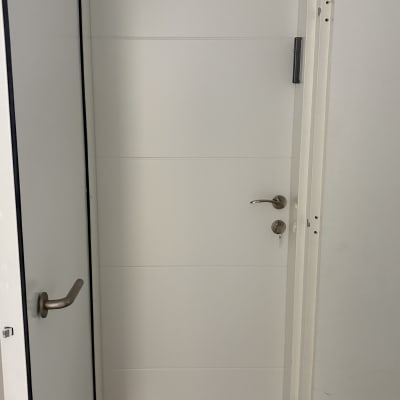 דלת לבנה עם ידית כסופה ומנעול