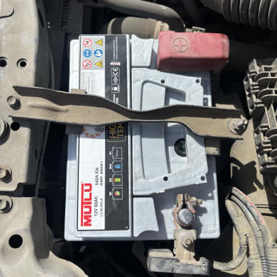 מצבר רכב מותקן בתא מנוע עם חיבורים חשמליים