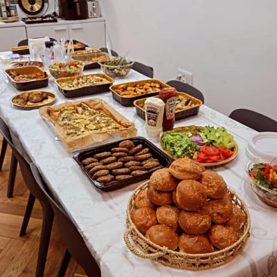 שולחן ערוך עם מגוון מאכלים, לחמניות וסלטים