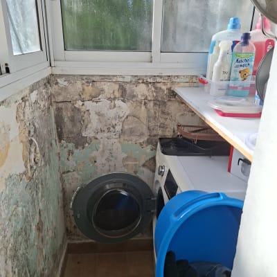 חדר כביסה עם מכונת כביסה ודלי כחול