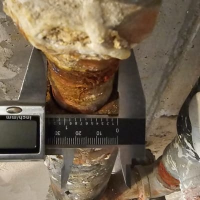 צינור חלוד עם מדידה בכלי עבודה