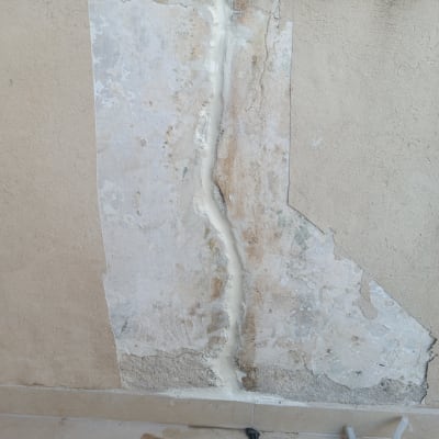 קיר עם סדק מתוקן בחומר איטום לבן