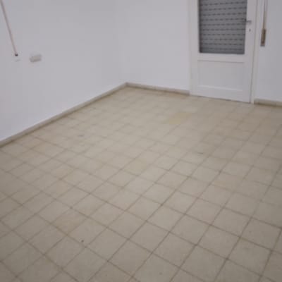 רצפה מרוצפת נקייה בחדר ריק עם דלת לבנה