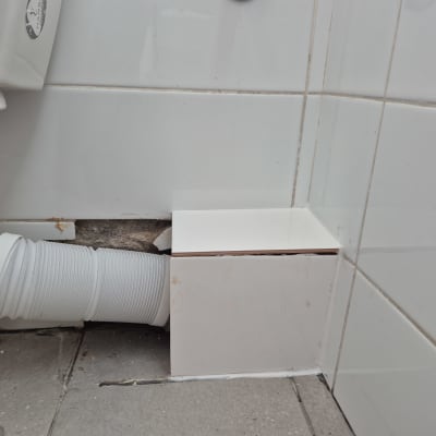 צינור פלסטיק לבן מחובר לקיר אריחים