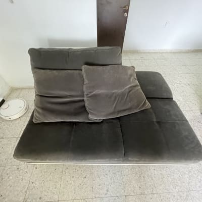 ספה אפורה עם כריות ורובוט שואב אבק