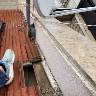 תמונה של גג רעפים עם צלחת לוויין ועבודת תיקון
