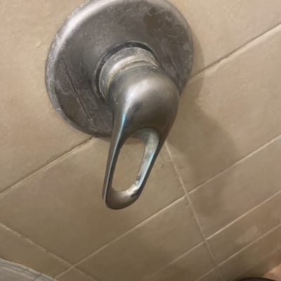 ידית ברז מתכתית על קיר אריחים