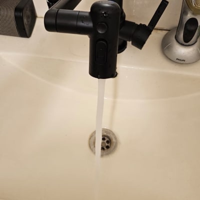 ברז שחור עם תצוגת טמפרטורה זורם בכיור