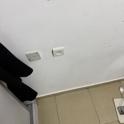 שקע חשמל על קיר לבן עם רצפת אריחים