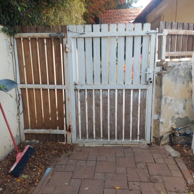 שער עץ מתכת עם מטאטא על הקרקע לידו