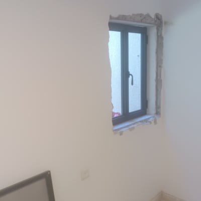 חלון אלומיניום מותקן בקיר עם מסגרת שבורה