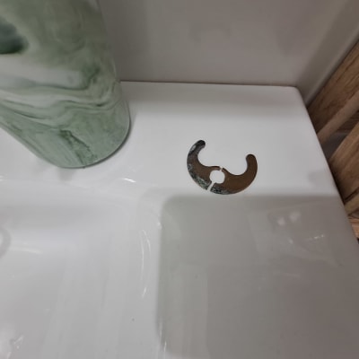 חלק מתכת על כיור לבן ליד כלי ירוק