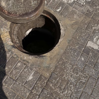 פתח ביוב פתוח על מדרכה