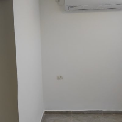 A white painted wall with an air conditioner.