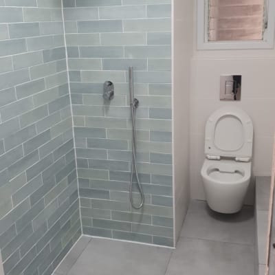 מקלחת חדשה עם אריחים אפורים וראש גשם