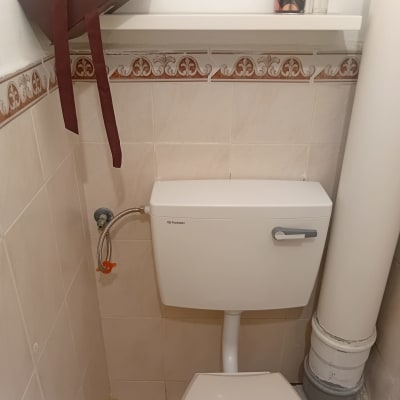 אסלה עם מיכל הדחה וצינור מים