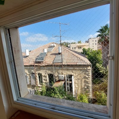 רשת יונים מותקנת על חלון למניעת כניסת יונים