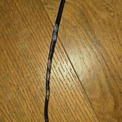 כבל חשמלי עם חיבורים חשופים על שולחן עץ