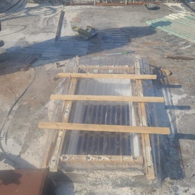 עבודת איטום על גג עם לוחות עץ וחומרים שונים