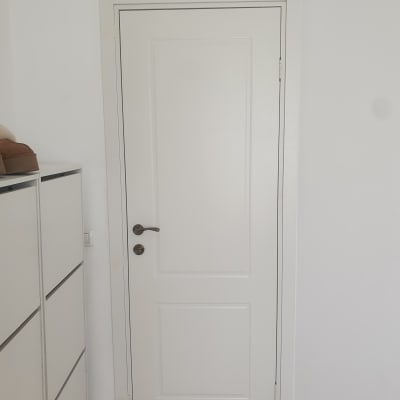 דלת לבנה עם ידית מתכת כהה