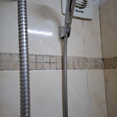 מקלחת עם צינור מתכת וראש מקלחת