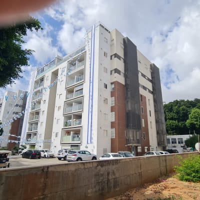 בניין מגורים עם מכוניות חונות בחזית