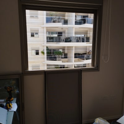 מסגרת אלומיניום לחלון עם רשת מונחת בצד