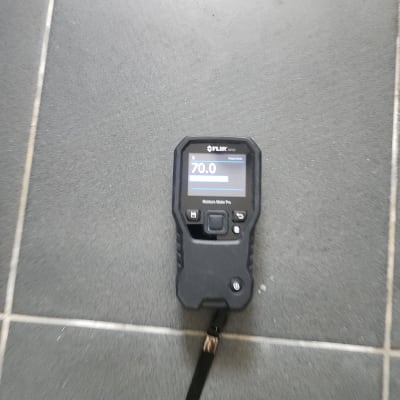 מד לחות על רצפה אפורה, קשור לאיתור נזילות.