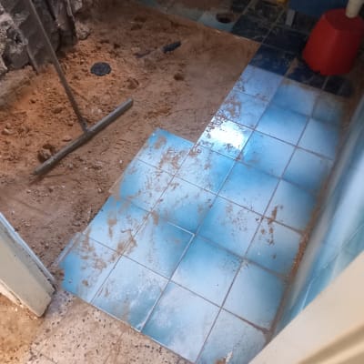 רצפה עם אריחים כחולים וכלי עבודה לשיפוץ