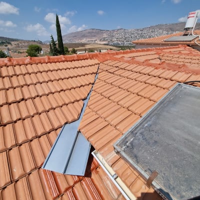 גג רעפים עם לוחות מתכת ודוד שמש