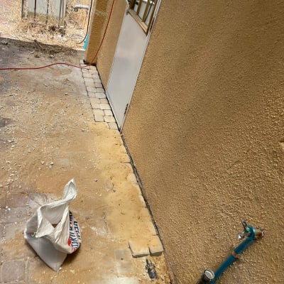 צינור מים כחול מחובר לקיר ליד דלת לבנה