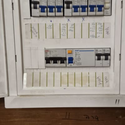 לוח חשמל עם מפסקים וכיתובים בעברית