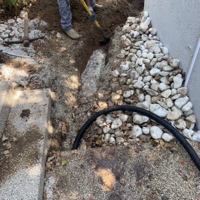 אדם חופר תעלה עם את חפירה ליד צינור חשמל