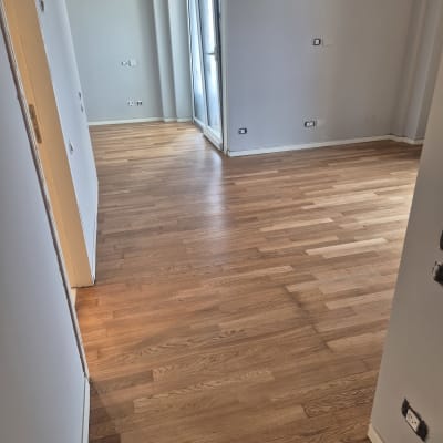 רצפת עץ חדשה בחדר ריק עם קירות אפורים