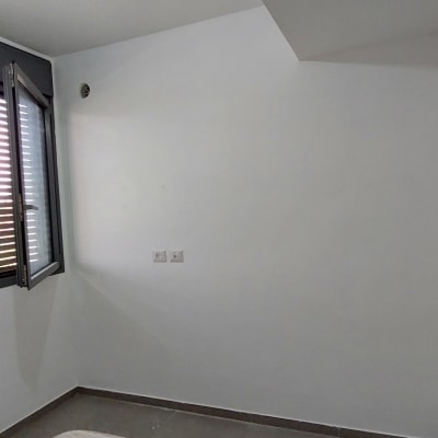 קיר לבן עם חלון פתוח ותריסים