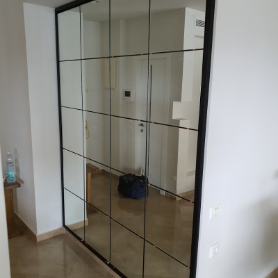 מראה גדולה עם מסגרת שחורה על קיר לבן