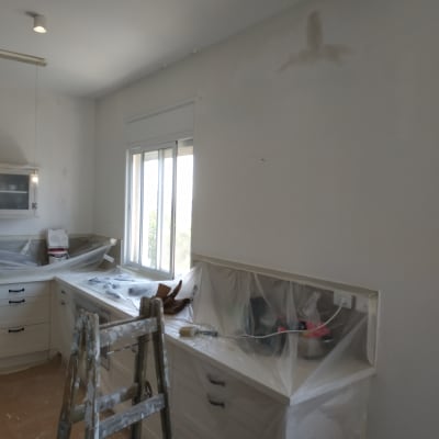 סולם וחומרי צביעה במטבח במהלך שיפוץ